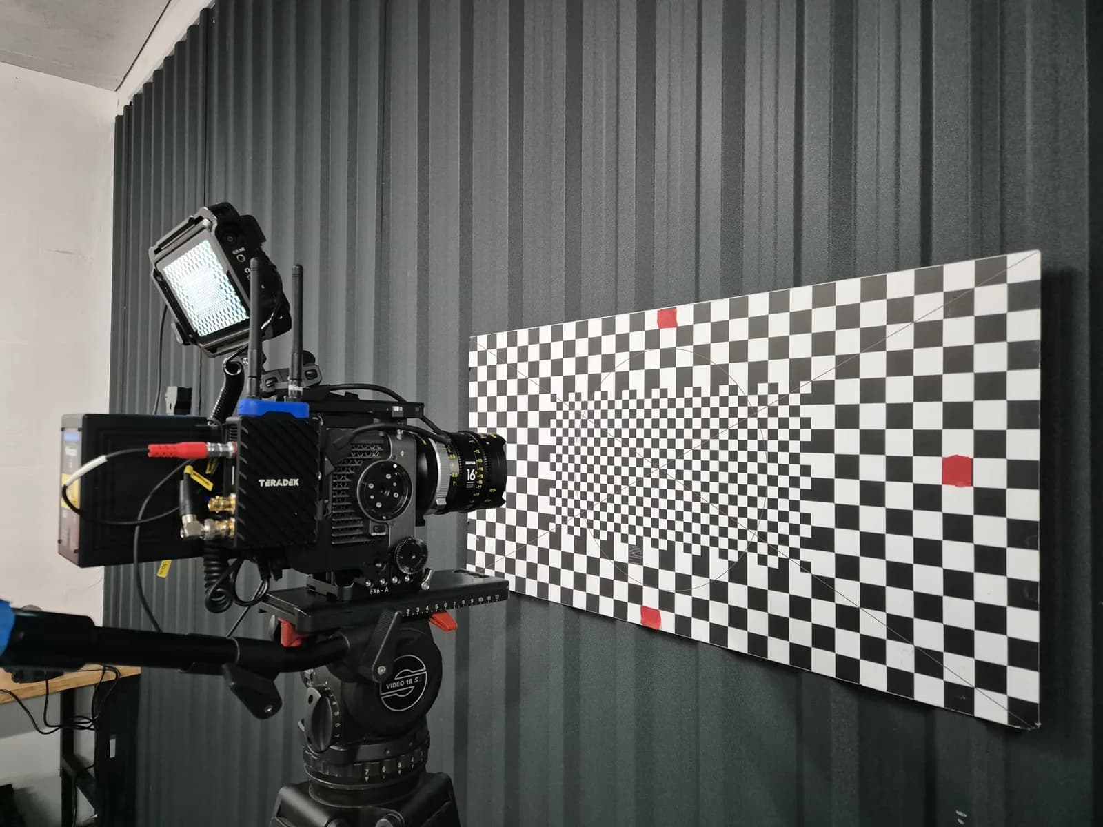 Cinema camera and calibration chart in a technical workspace